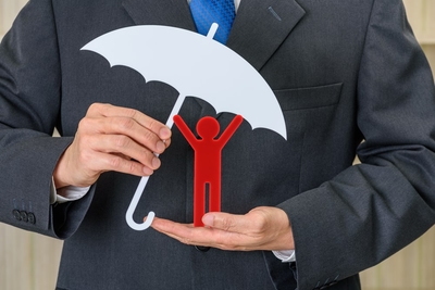 Person Holding A Toy Human Figurine With Umbrella